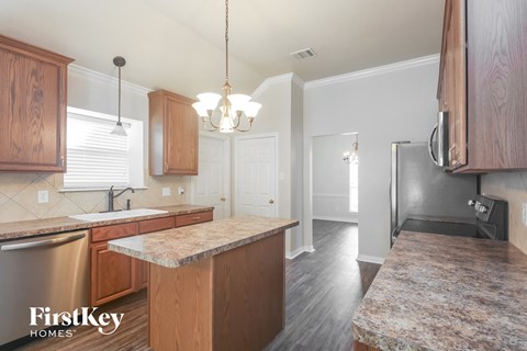 a kitchen with wood cabinets and granite counter tops and a stainless steel refrigerator