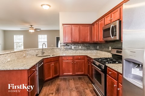 A kitchen with wooden cabinets and a stove top oven.