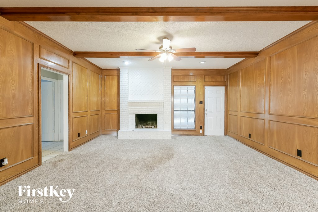 A spacious room with wooden walls and a fireplace.
