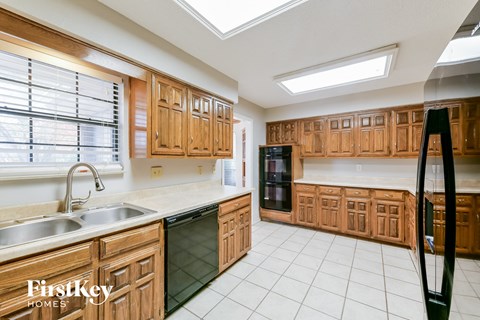 A kitchen with wooden cabinets and a skylight.