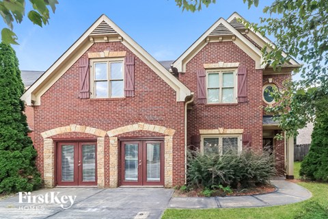 front view of a brick house with red doors