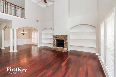 a living room with a fireplace and wooden floors
