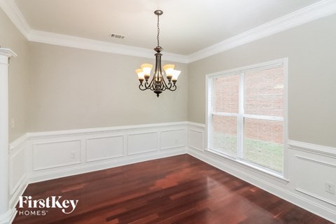 a dining room with a large window and a chandelier