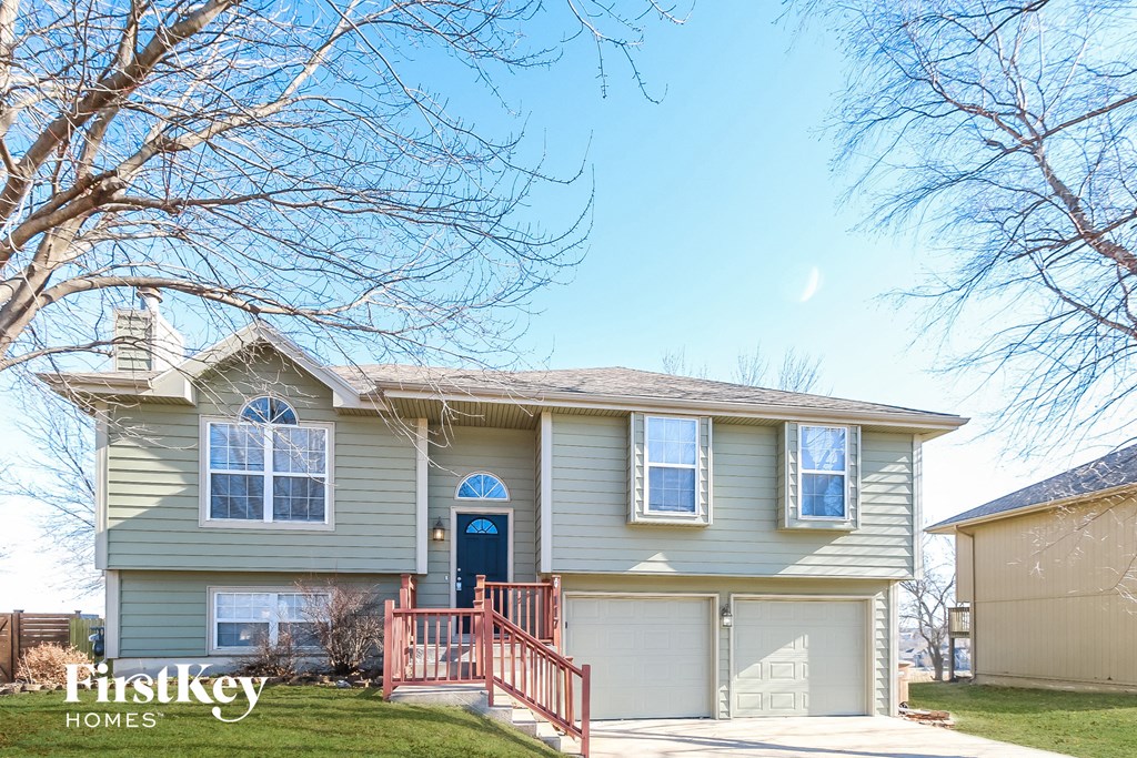 a beige house with a blue door and a porch