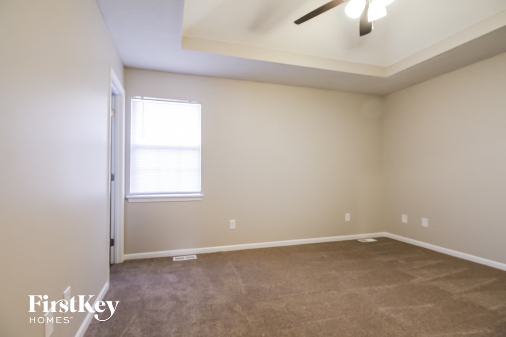 a empty room with a ceiling fan and a window
