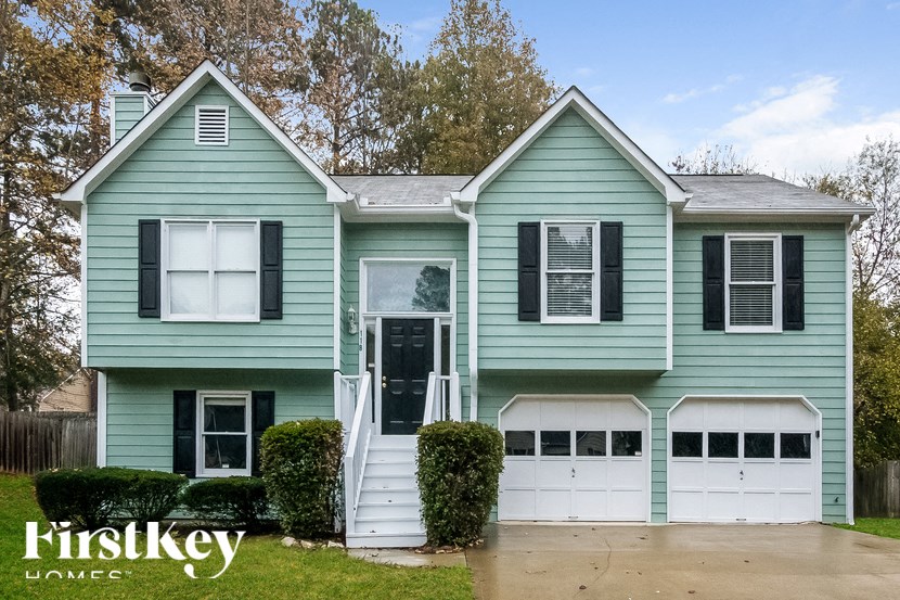 a blue house with white garage doors