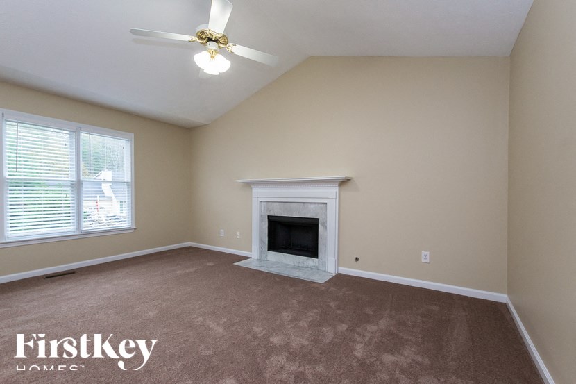 a living room with a fireplace and a ceiling fan
