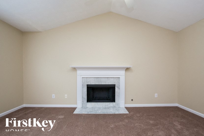 the living room has a fireplace and carpeted floors