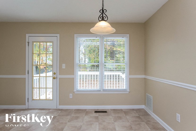 an empty dining room with a window and a door
