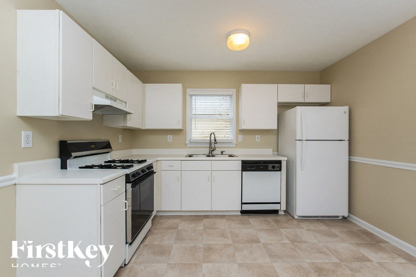 a kitchen with white cabinets and a stove and refrigerator