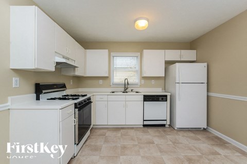 a kitchen with white cabinets and a stove and refrigerator