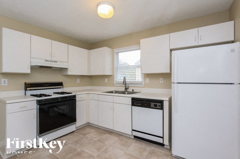 a white kitchen with white appliances and white cabinets