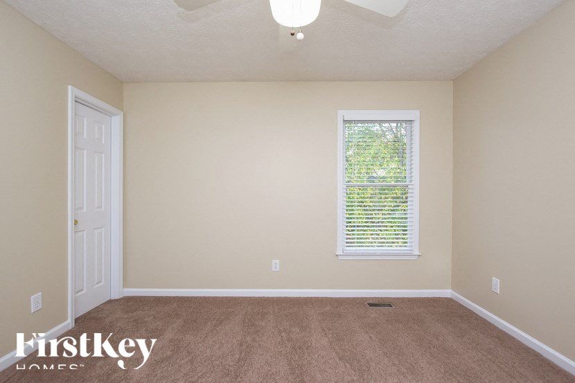 a bedroom with a carpeted floor and a window