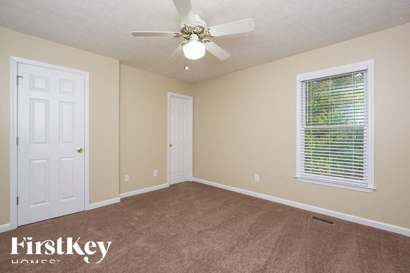 an empty room with a ceiling fan and a window