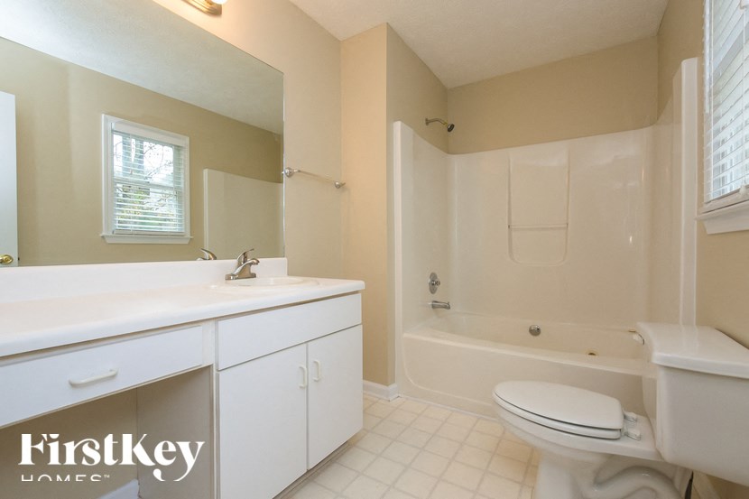 a bathroom with a toilet and a sink and a bath tub