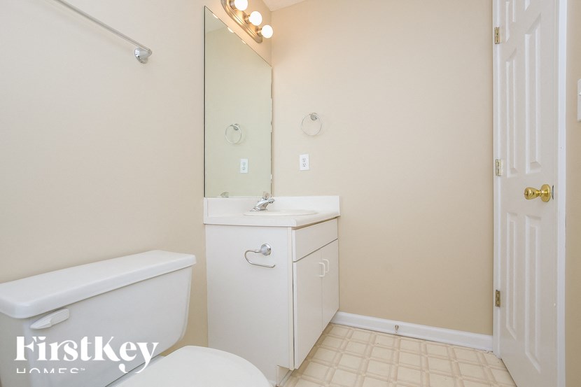 a bathroom with a toilet and a sink and a mirror