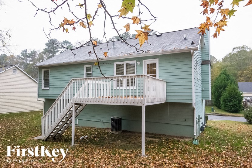 a blue house with a porch and a white deck