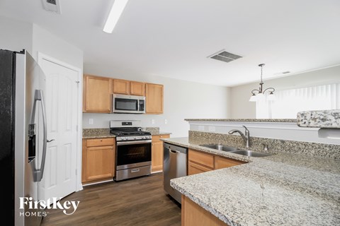 A kitchen with granite countertops and wooden cabinets.