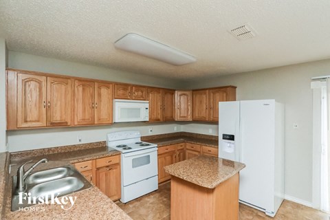 A kitchen with wooden cabinets and a granite countertop.