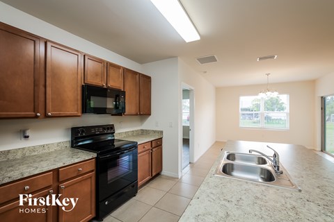 A kitchen with brown cabinets and a black stove top oven.