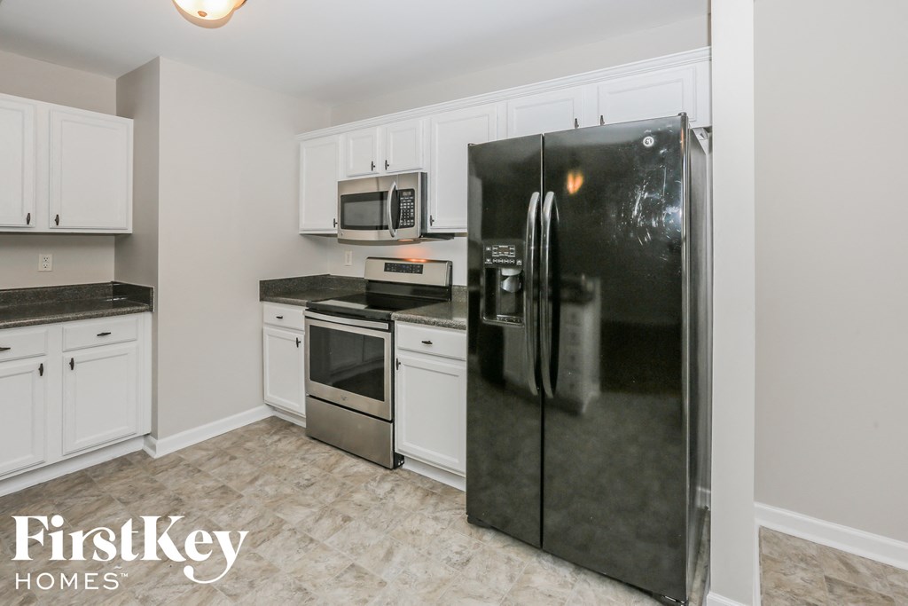 a kitchen with stainless steel appliances and white cabinets