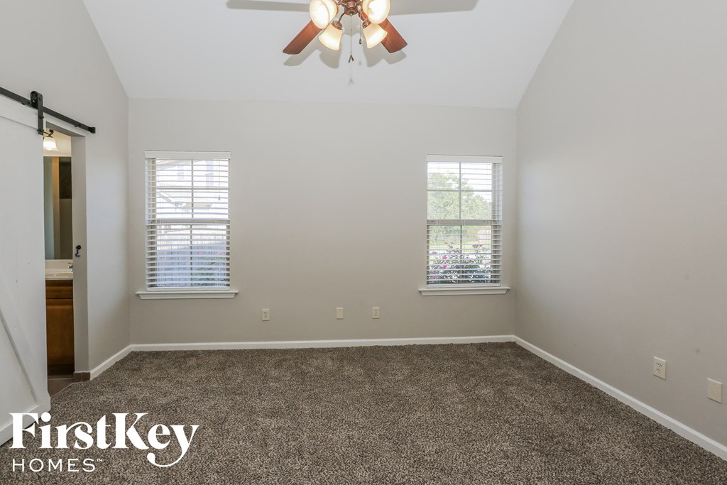 a bedroom with a carpeted floor and a ceiling fan