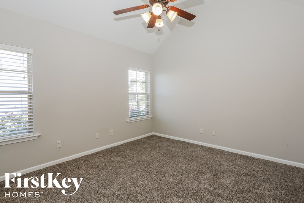 a bedroom with a carpeted floor and a ceiling fan