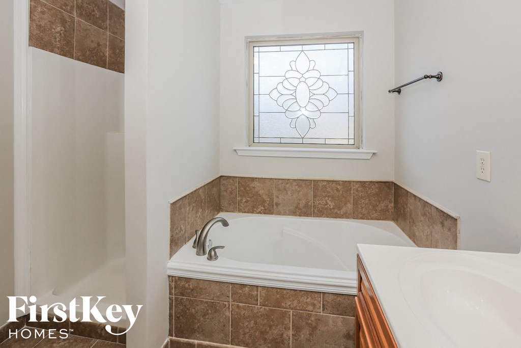 a bathroom with a tub and a sink and a window