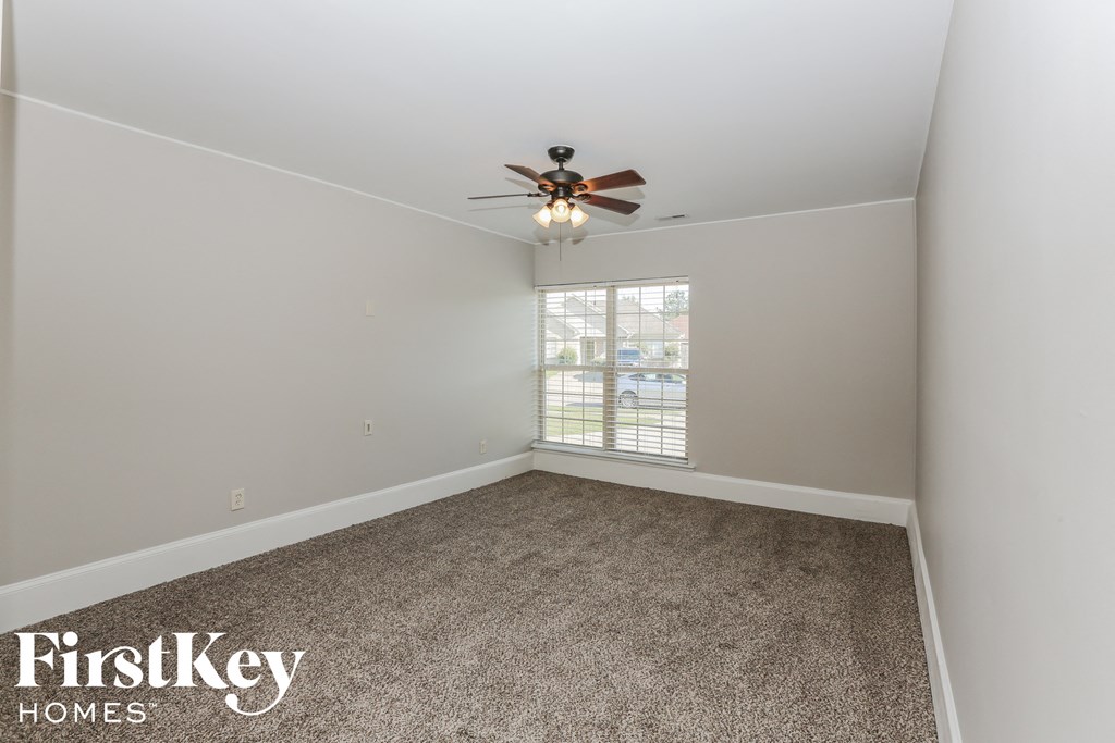 an empty room with a ceiling fan and a window