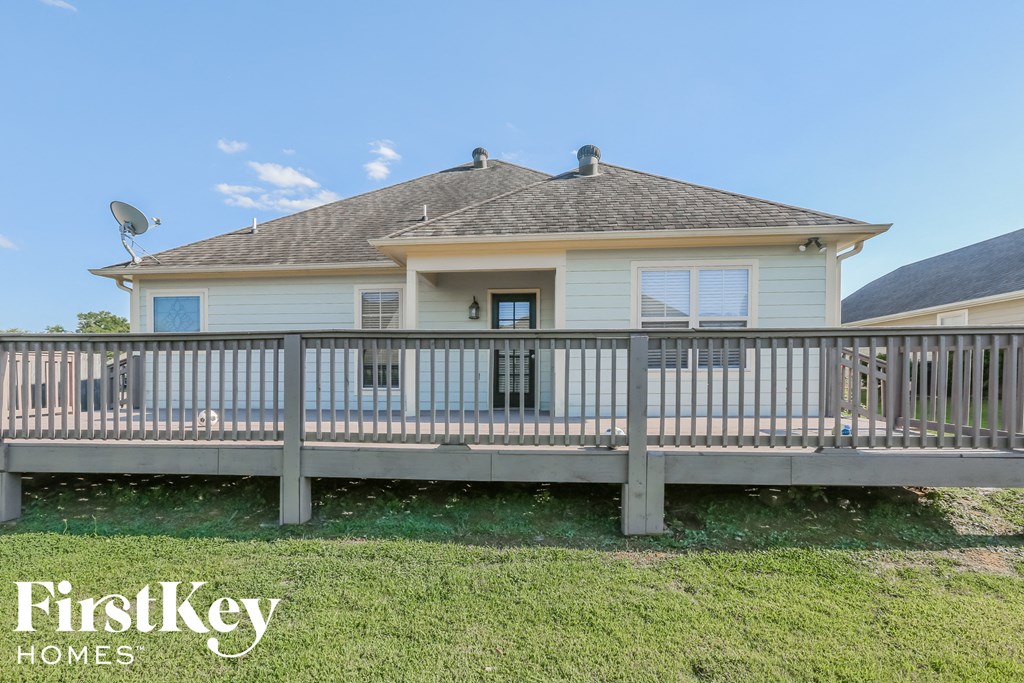 a house with a deck and a fence in front of it