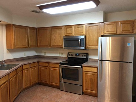 A kitchen with wooden cabinets and stainless steel appliances.