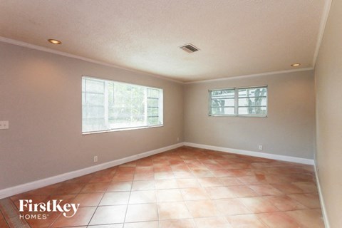 A room with a tile floor and two windows.