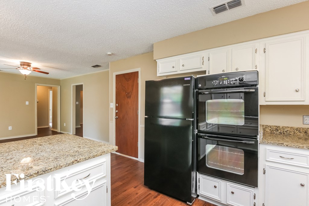 a kitchen with black appliances and white cabinets