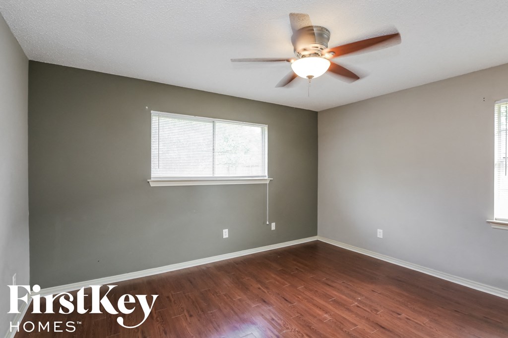 an empty room with a ceiling fan and a window
