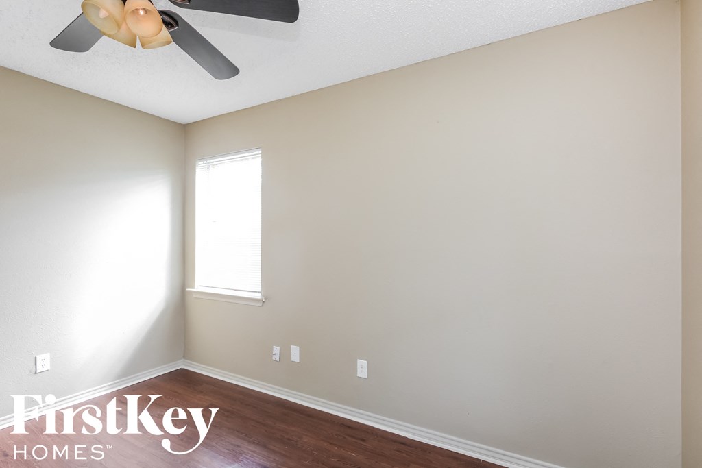 a empty room with a ceiling fan and a window