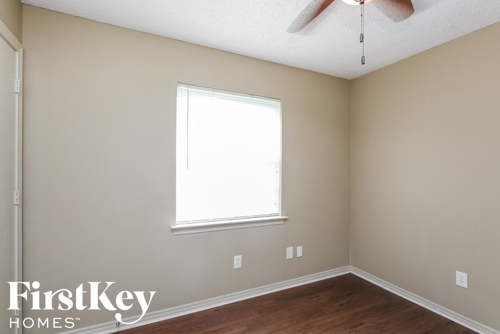 a bedroom with a ceiling fan and a window