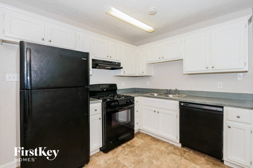 a kitchen with black appliances and white cabinets