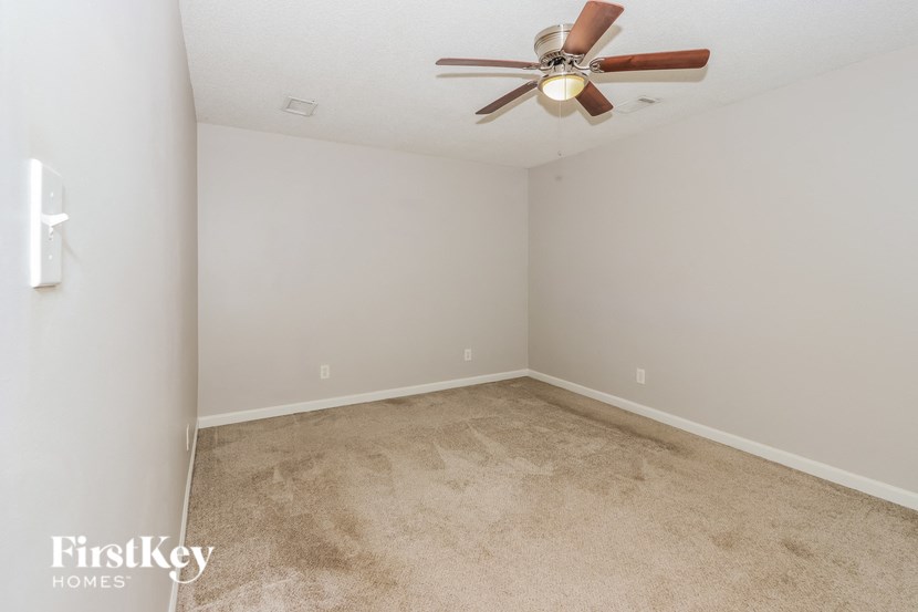 a room with carpet and a ceiling fan