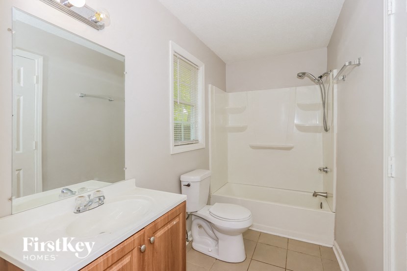 a bathroom with a shower toilet and sink and a mirror