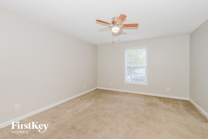 a bedroom with carpet and a ceiling fan