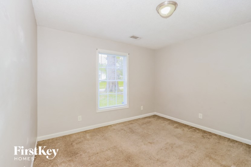 a bedroom with a carpeted floor and a window