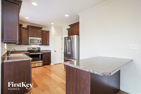 A kitchen with wooden cabinets and a stainless steel refrigerator.