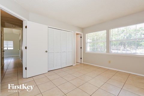 a living room with a door to a hallway and a tiled floor
