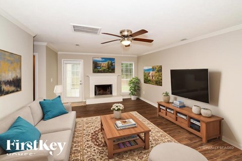A living room with a couch, a coffee table, a fireplace, a television, and a painting on the wall.