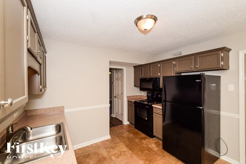A kitchen with a black refrigerator and stove.
