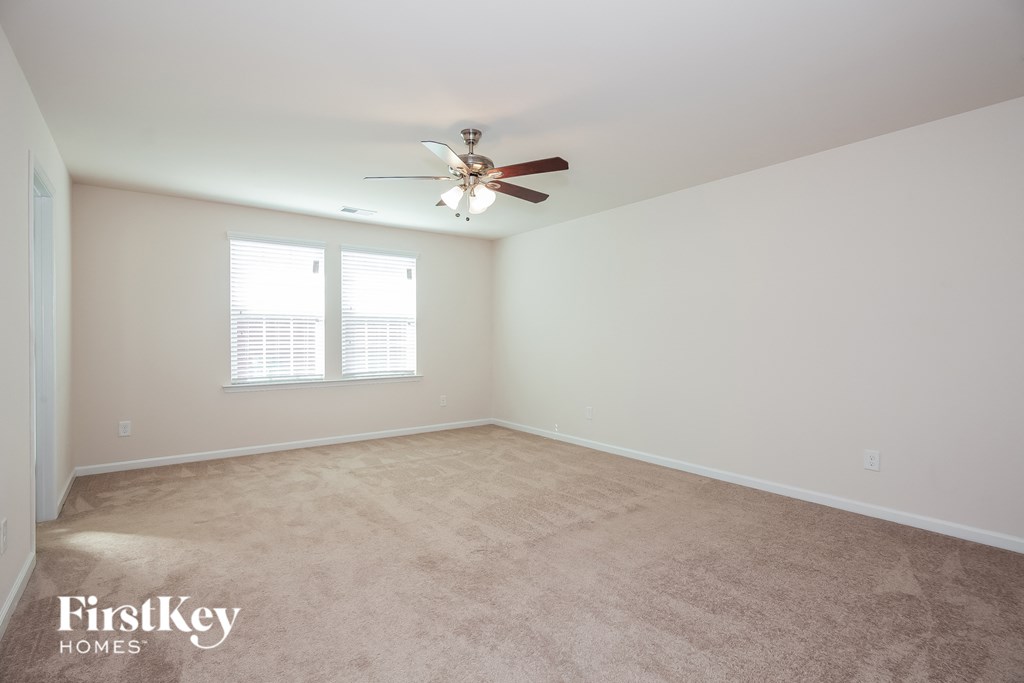 a bedroom with carpet and a ceiling fan