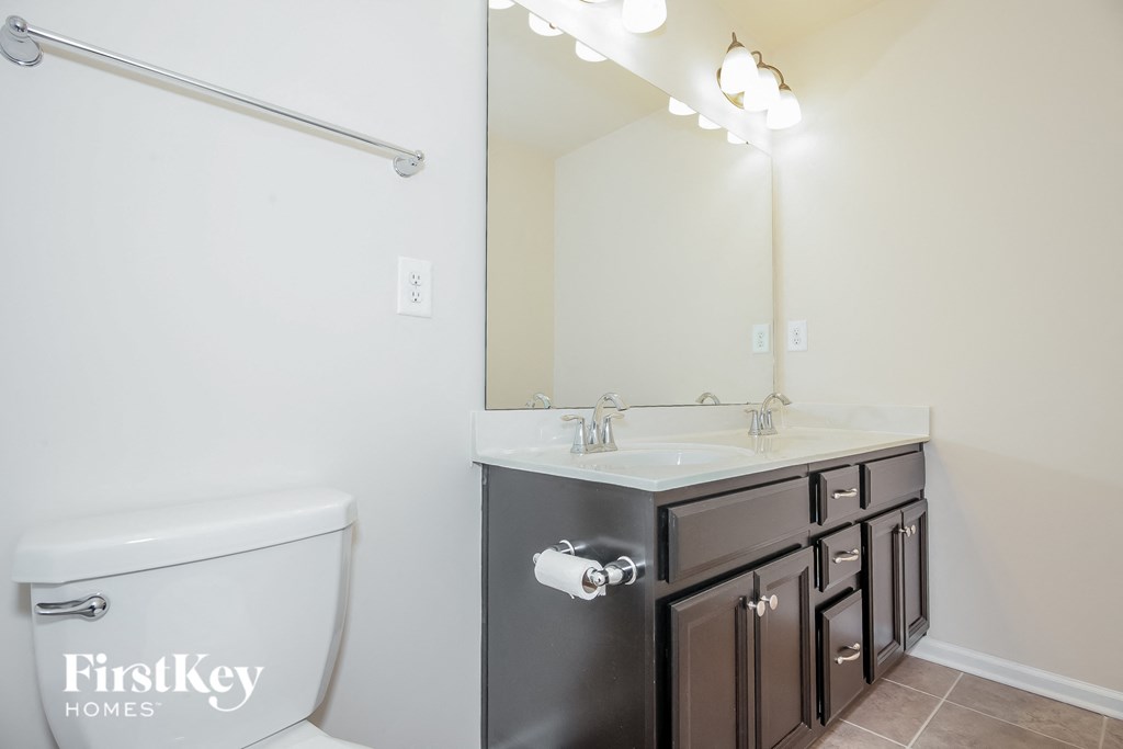 a bathroom with a toilet and a sink and a mirror