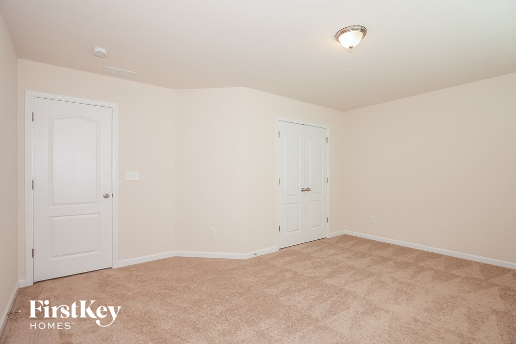 a bedroom with two closets and a carpeted floor