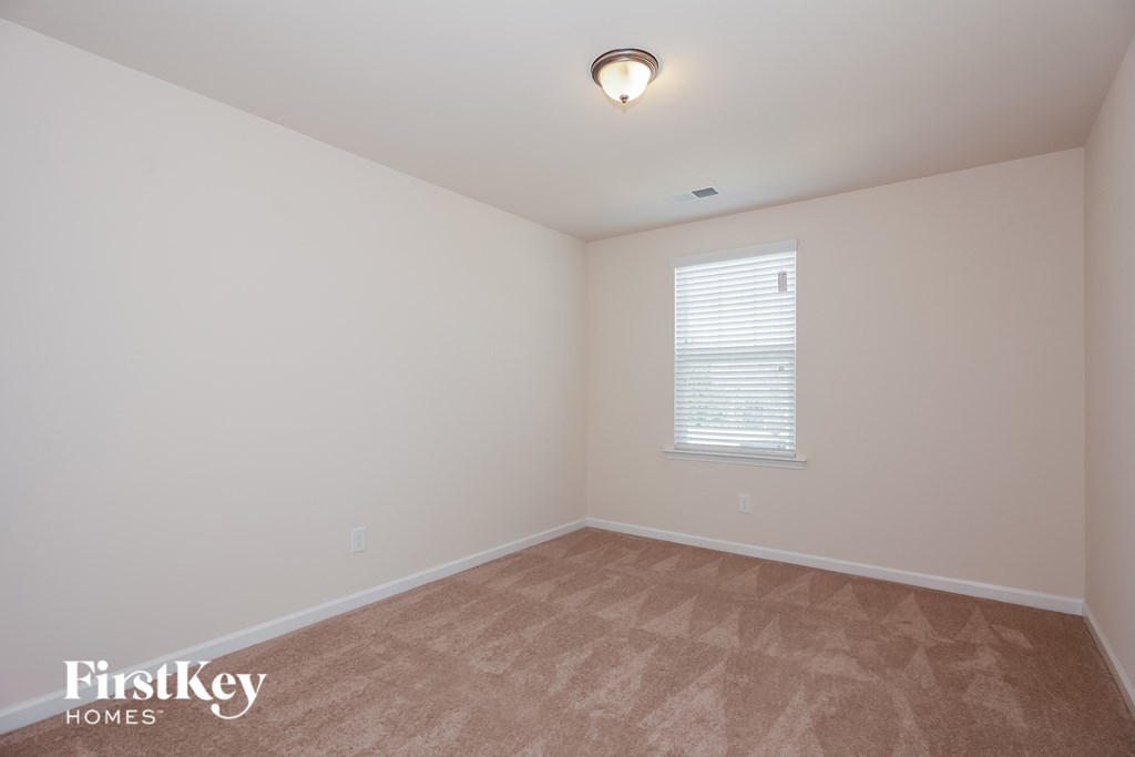 a bedroom with a carpeted floor and a window