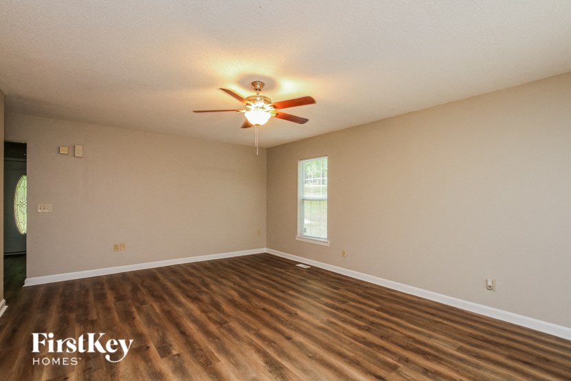 A room with a ceiling fan and wooden flooring.